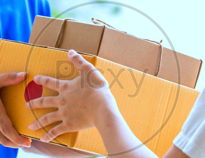 Woman Hand Accepting A Delivery Of Boxes From Deliveryman