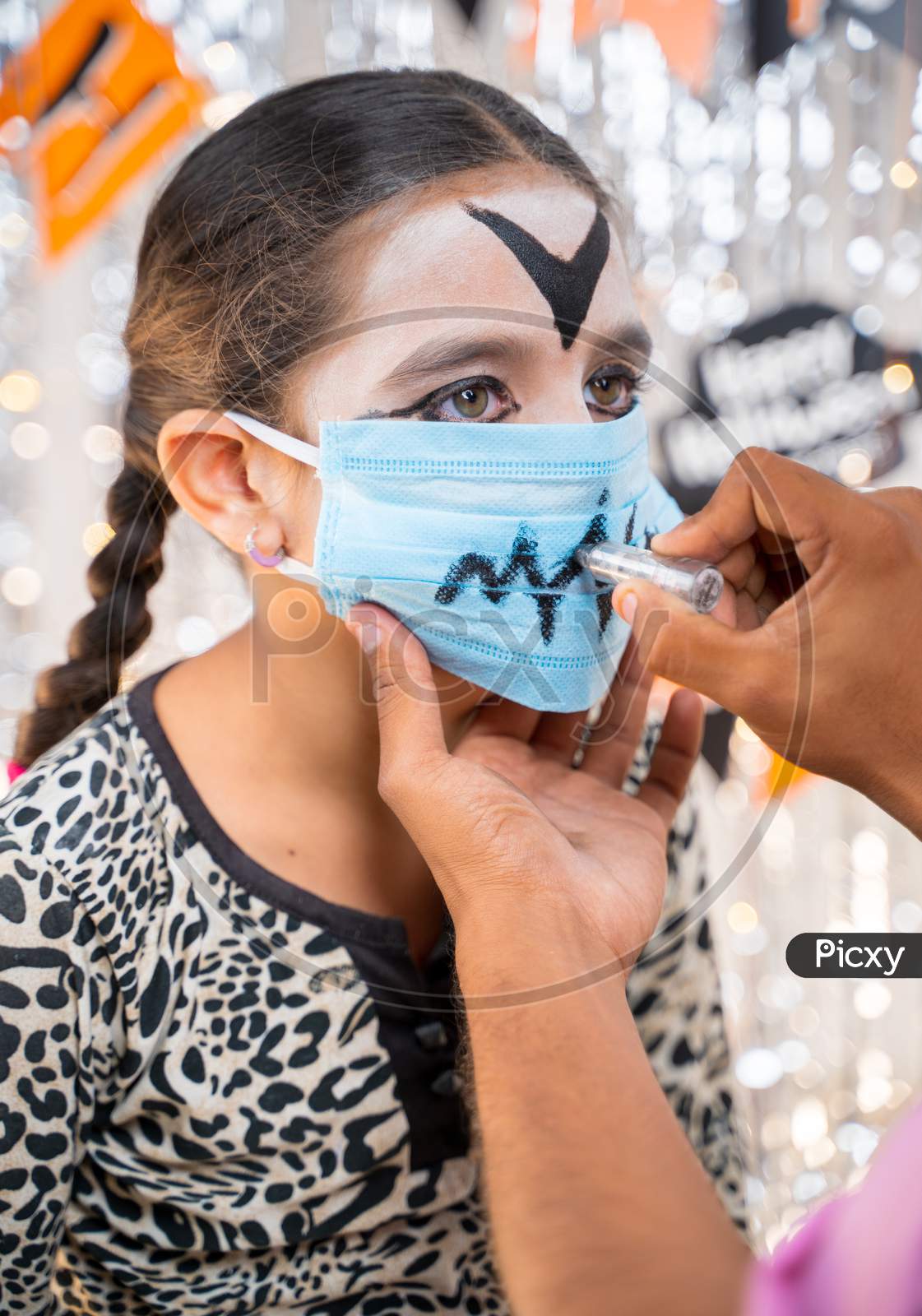 Kid Getting Ready Or Preparing For Halloween By Painting On Medical Face Mask - Concept Of Holiday, Halloween, And Childhood Festival Celebration And Preparation.