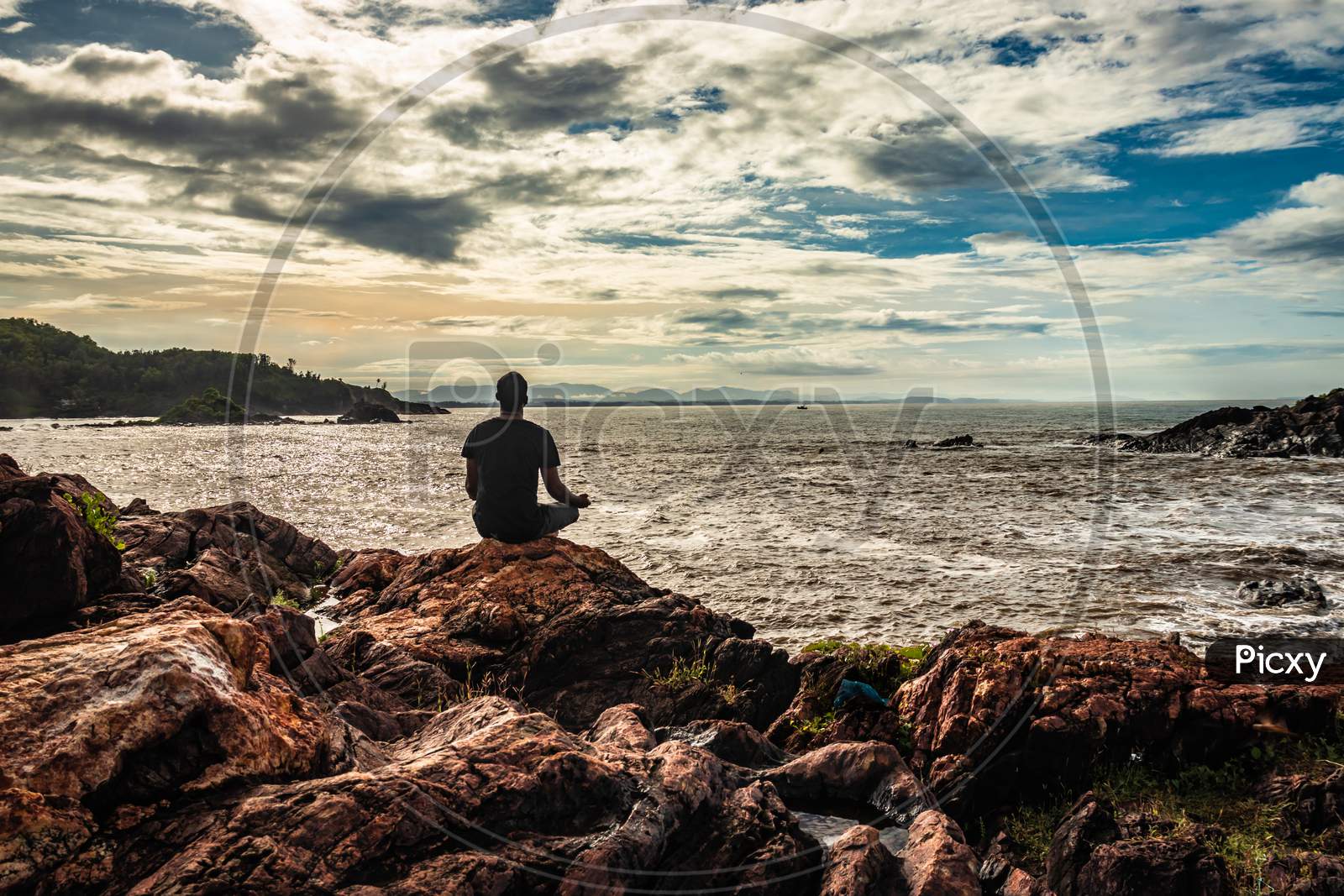 Man Meditating At Rock At Sea Shore At Morning From Flat Angle