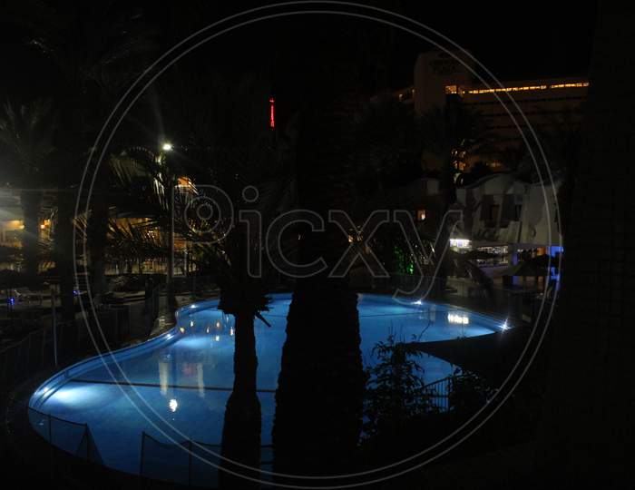A large and beautiful pool sparkles at night