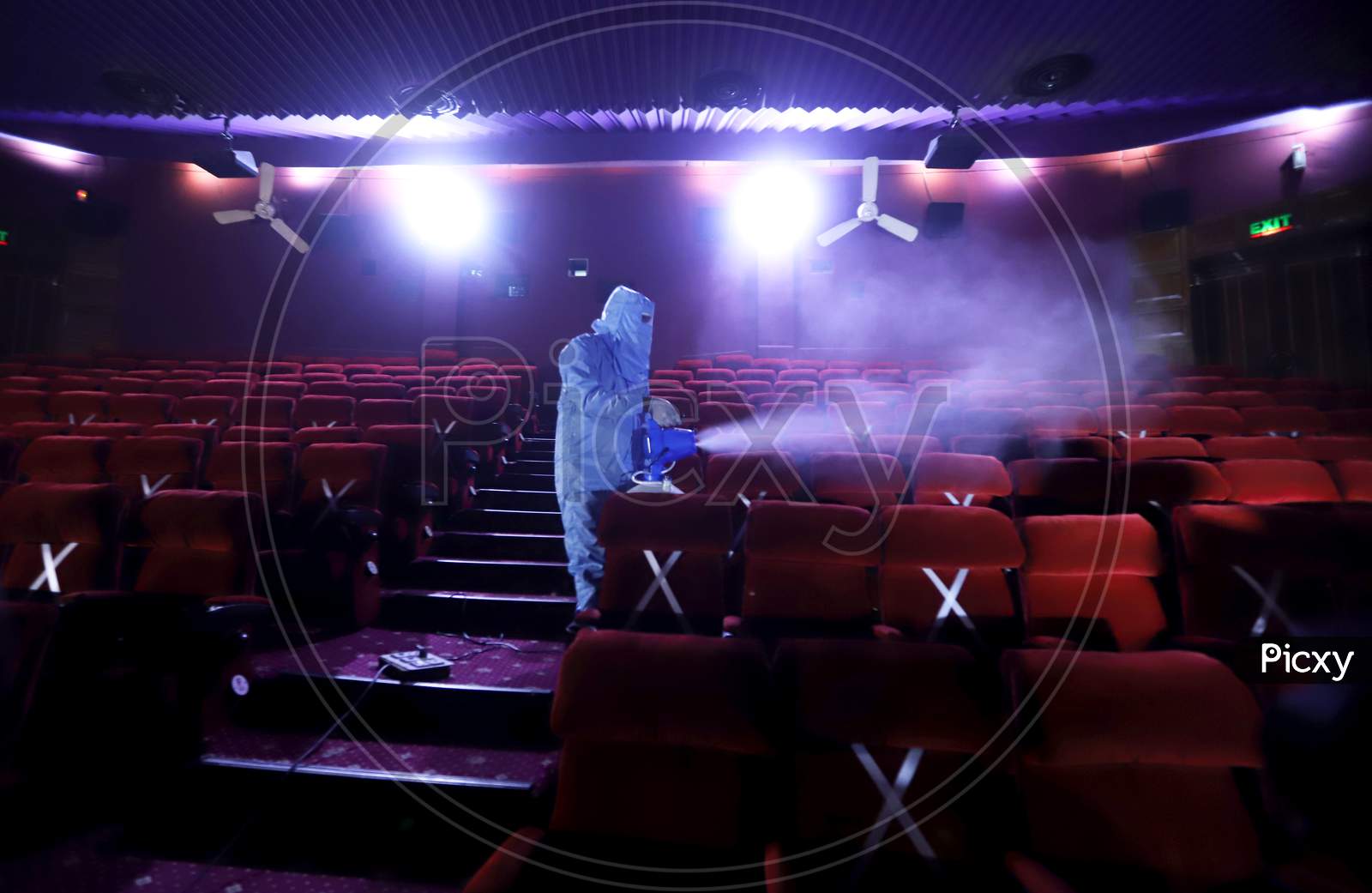 A worker sanitises inside a theatre hall ahead of the scheduled reopening of cinema theatres on October 15 as the Covid-19 coronavirus imposed lockdown eases further in New Delhi on October 13, 2020.
