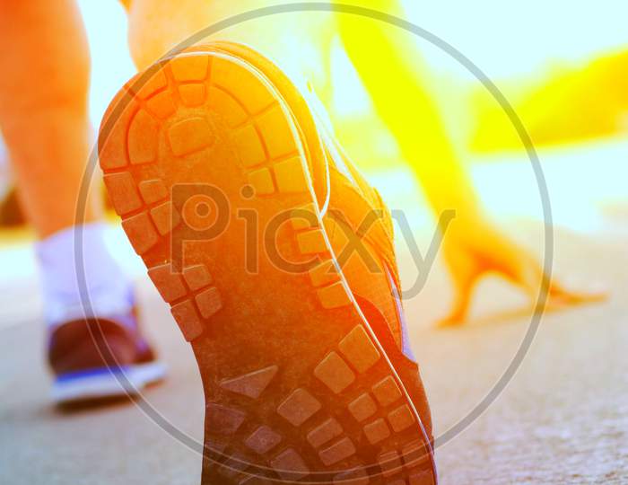 Athlete Runner Feet Running On Treadmill Closeup On Shoe.Mans Fitness With The Sun Effect In The Background And Open Space Around Him