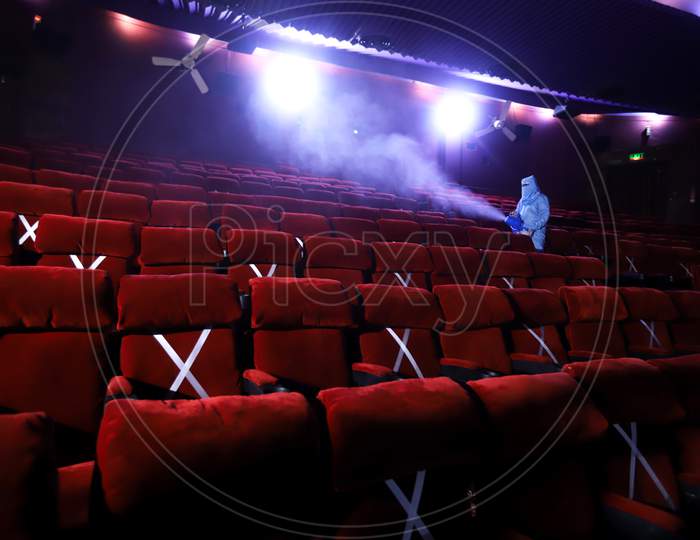 A worker sanitises inside a theatre hall ahead of the scheduled reopening of cinema theatres on October 15 as the Covid-19 coronavirus imposed lockdown eases further in New Delhi on October 13, 2020.
