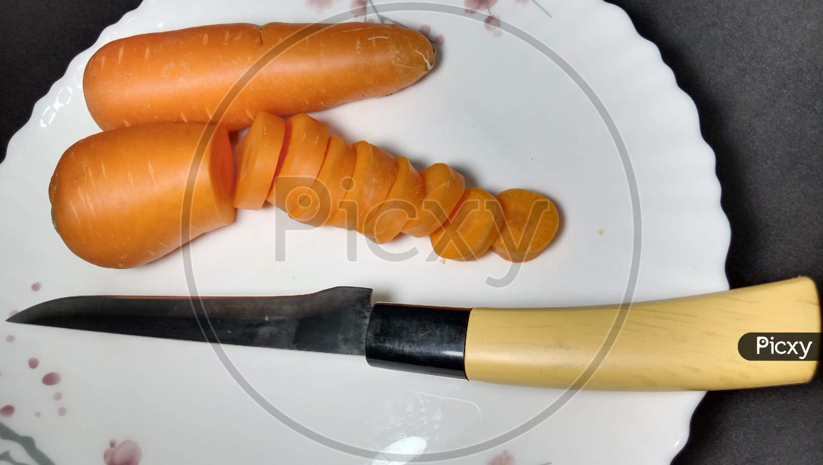 Fresh And Delicious And Healthy Carrot Pieces And A Knife