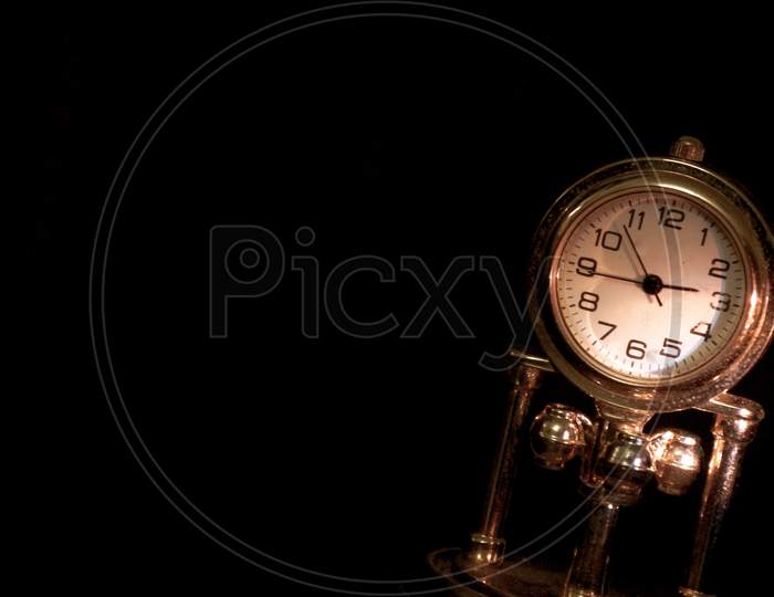 A closeup of an old antique analogue watch on a black background