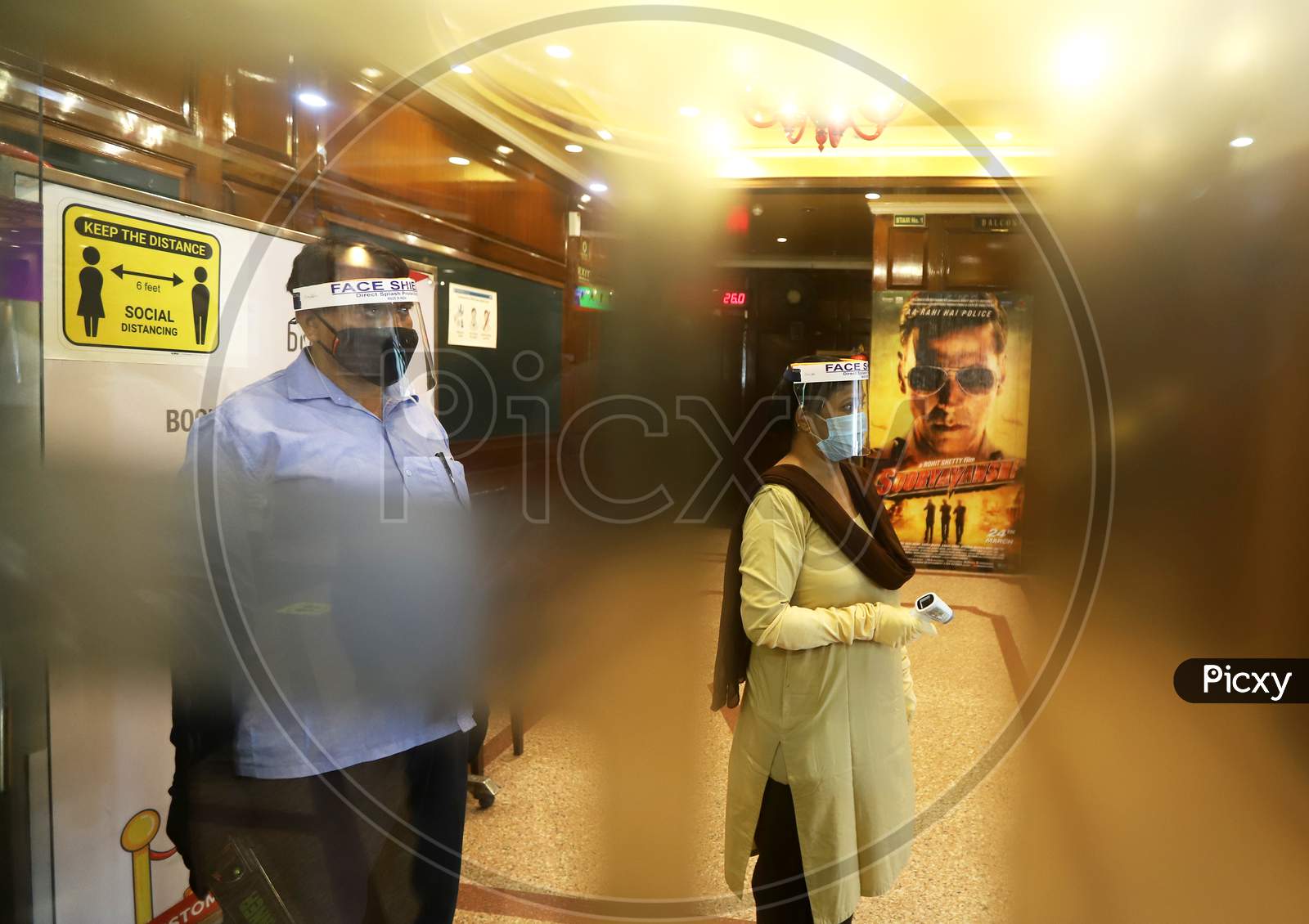 Workers wear facemasks and face shields  inside a theatre during a sanitisation work ahead of the scheduled reopening of cinema theatres on October 15 as the Covid-19 coronavirus imposed lockdown eases further in New Delhi on October 13, 2020.