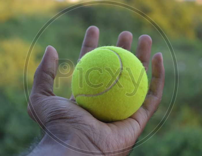 Tennis ball in a hand