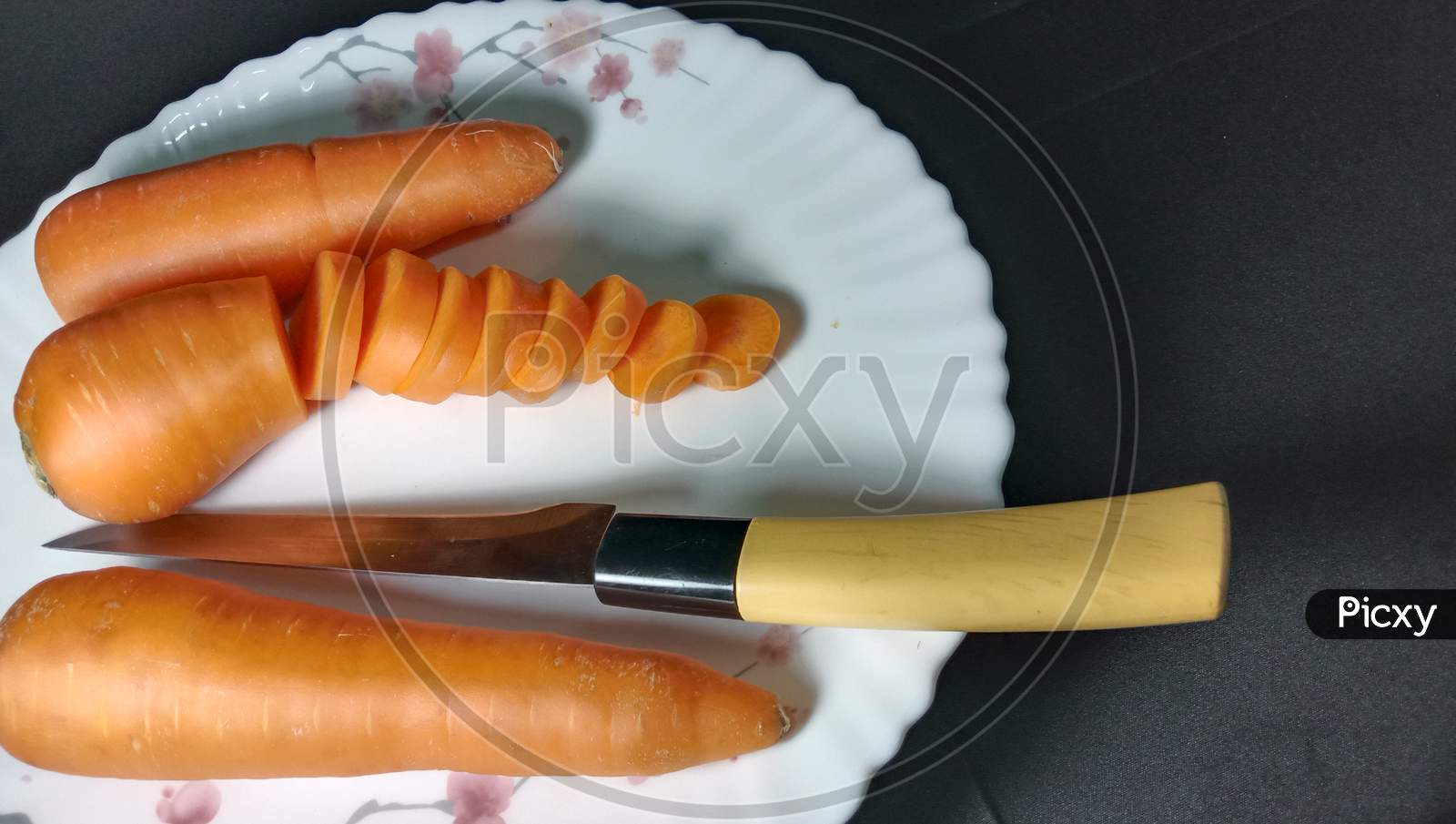 Fresh And Delicious And Healthy Carrot Pieces And A Knife