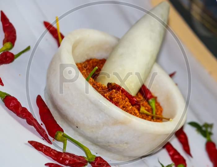 red hot chilli peppers and red chilli powder in the motor pestle