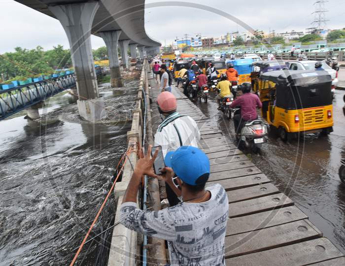 people watch Musi River water flowing at Attapur Bridge on October 14, 2020