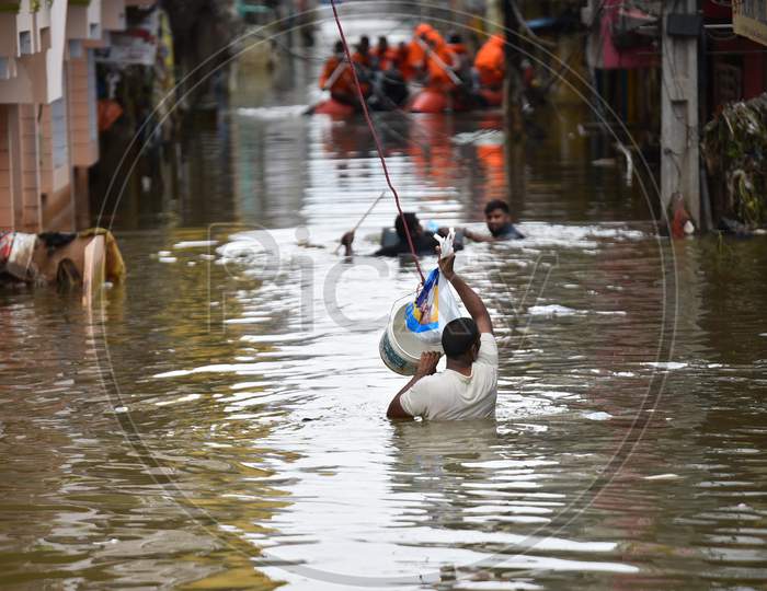 People carry Milk Packets to provide for the flood affected families in Al Jubail Colony, Falaknuma, October 14, 2020.