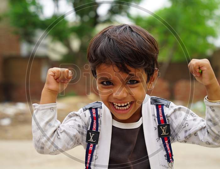 Happy boy child is smiling enjoying adopted life. Portrait of young boy in nature, park or outdoors. Concept of happy family or successful adoption or parenting.