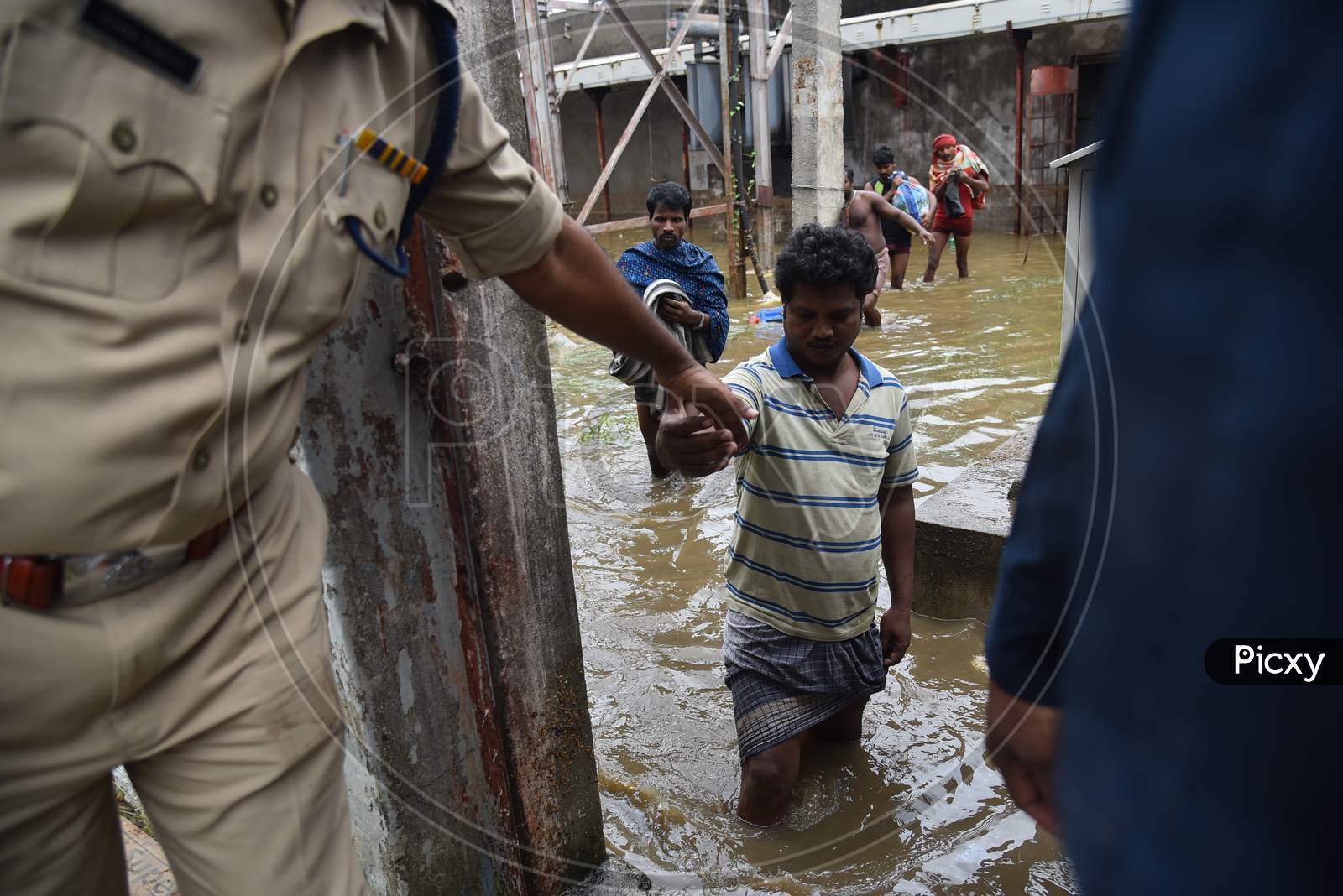 workers come out after being rescued by OCTOPUS team from a factory that got inundated due to the overflowing of Palle Cheruvu on October 14, 2020.