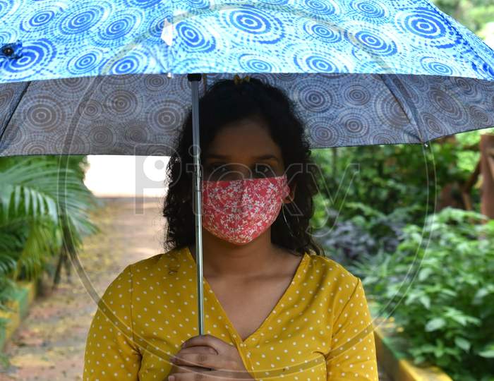 Girl in mask holding umbrella