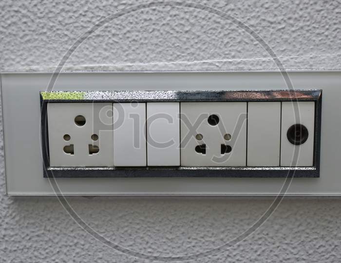 Designer Electrical Switch Board With 2 Pin Socket And Three Switch And Regulator On Zinc Paint Wall