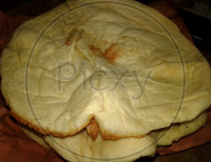 Naan Bread Close Up Photo Capture. Tandoori Naan. Bangladeshi And Indian Naan Roti. Naan Is A Leavened, Oven-Baked Flatbread Found In The Cuisines Mainly Of Western Asia, South Asia.