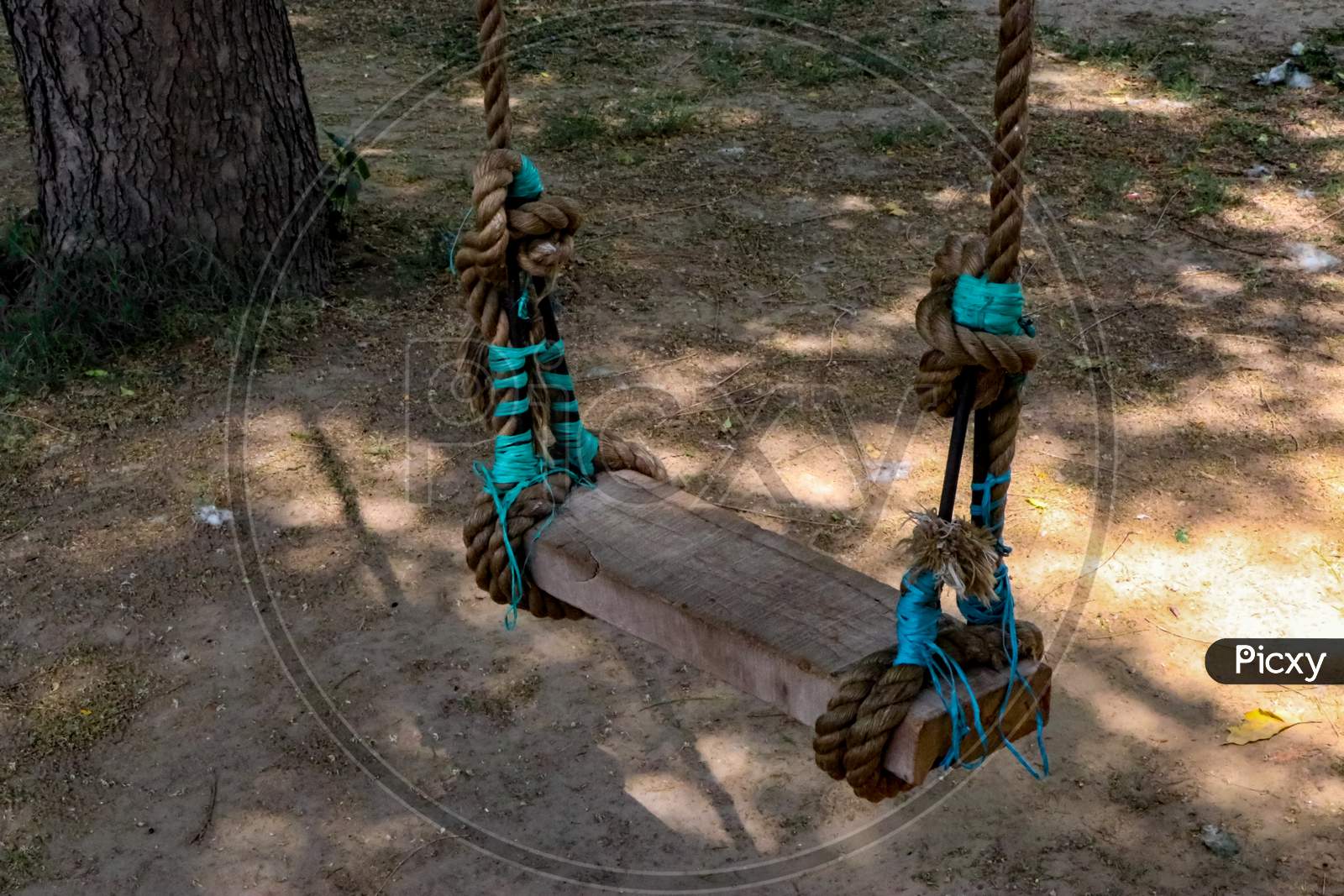 A wooden swing in the park.