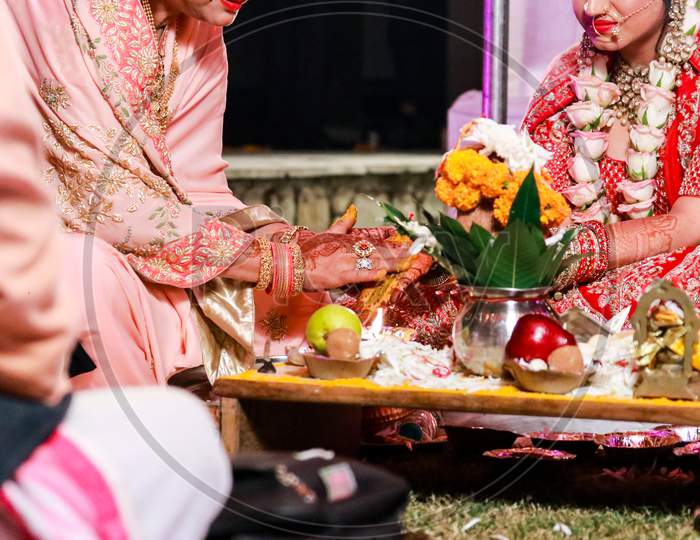 Indian Bride And Her Mother Performing A Ritual During The Wedding