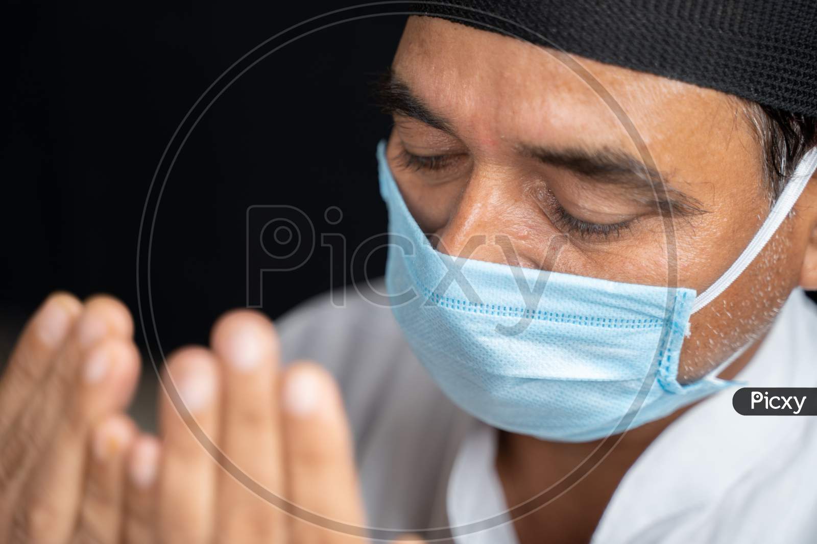 High Angle View Close Up Shot Of Muslim Man In Medical Mask Preforming Salah Or Prayer By Closing Eyes.