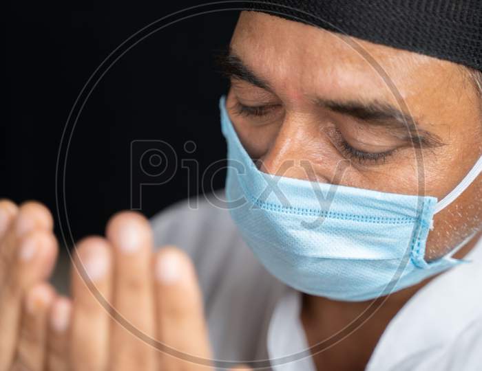 High Angle View Close Up Shot Of Muslim Man In Medical Mask Preforming Salah Or Prayer By Closing Eyes.