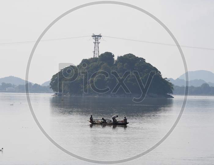 Fishermen paddle down the Brahmaputra river to fish, in Guwahati on oct 18,2020.