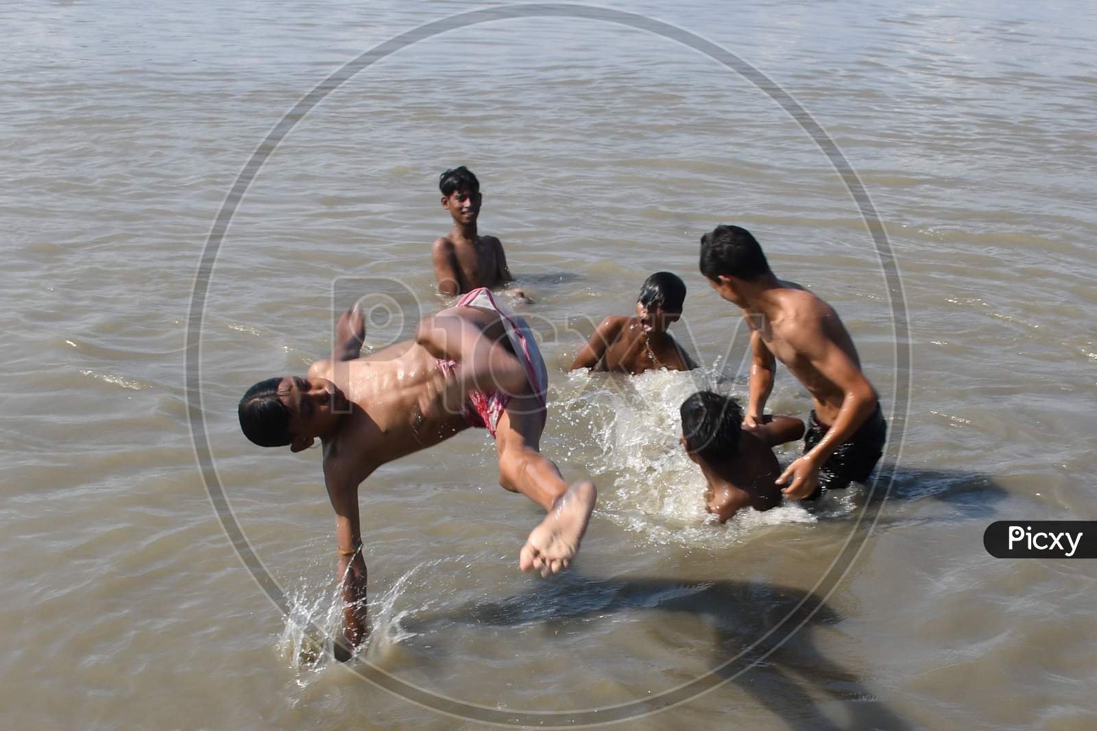 Image of Boys jump in the Brahmaputra river during a hot day in Guwahati  ,india on Oct 18,2020-TP733330-Picxy