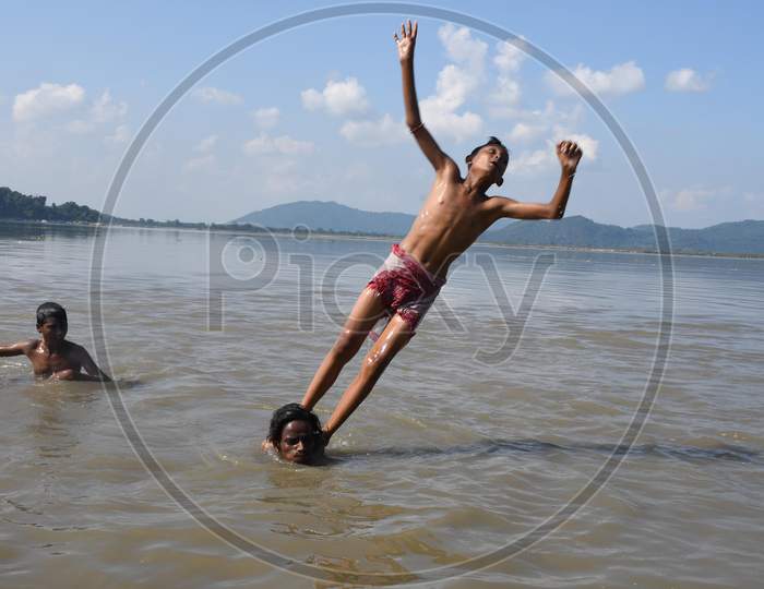 Boys jump in the Brahmaputra river during a hot day in Guwahati ,india on Oct 18,2020