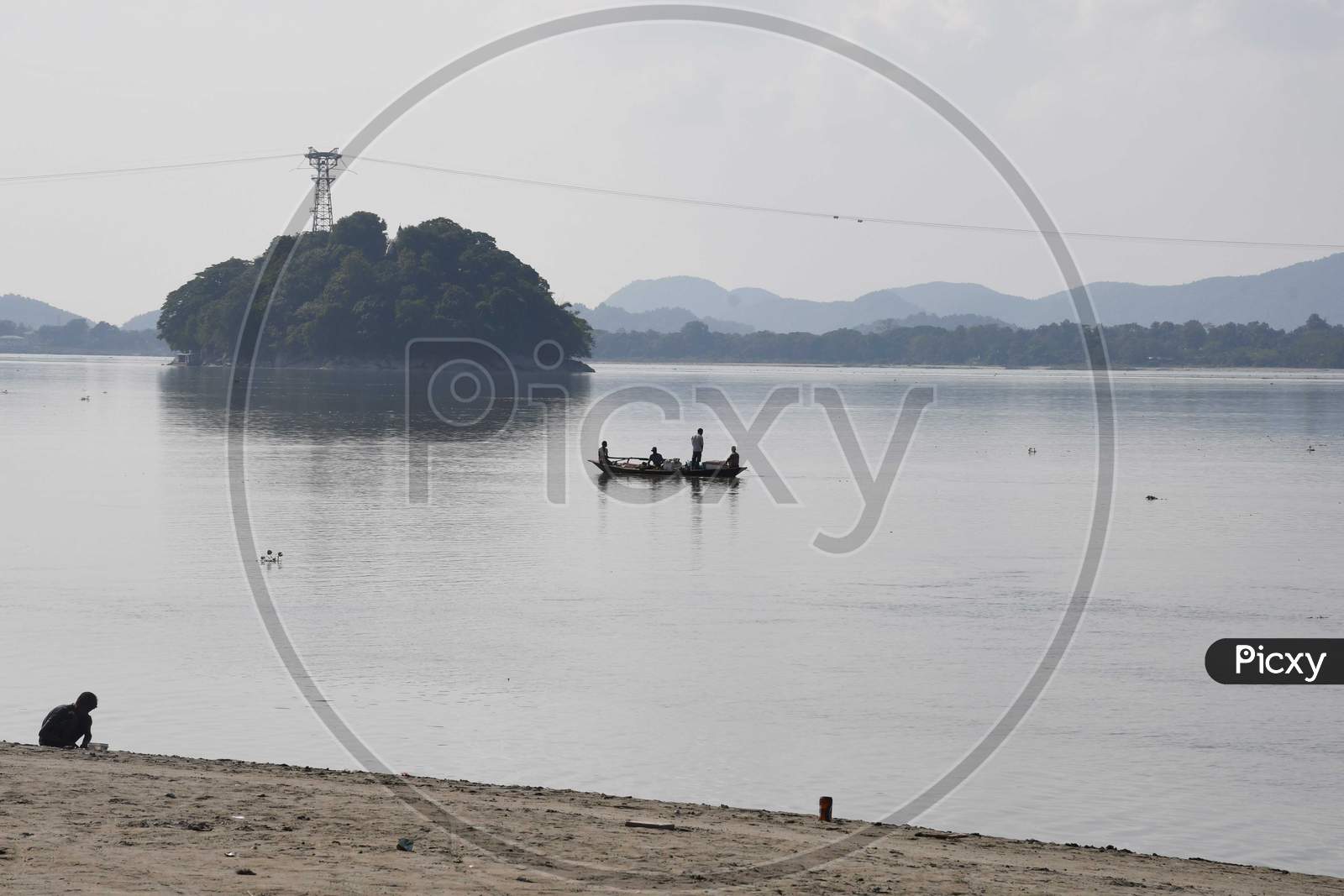 Fishermen paddle down the Brahmaputra river to fish, in Guwahati on oct 18,2020.