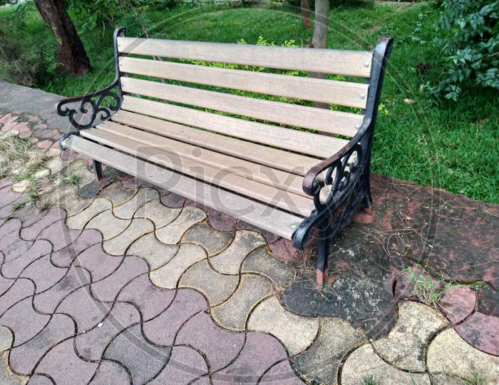 A empty wooden bench in the park from sideview.