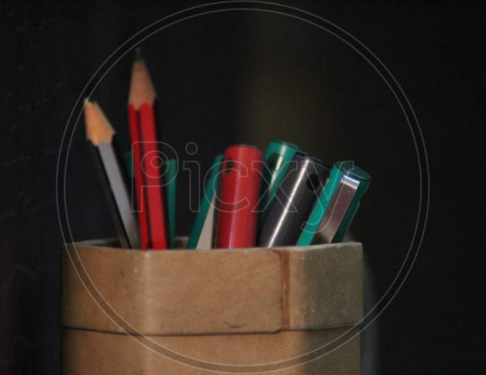 A PEN STAND WITH A COLLECTION PF PENS