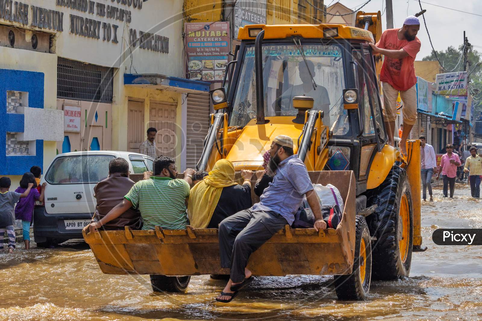 JCB carrying people in the flood water occupied streets in the Hafiz Baba Nagar due to Hyderabad floods