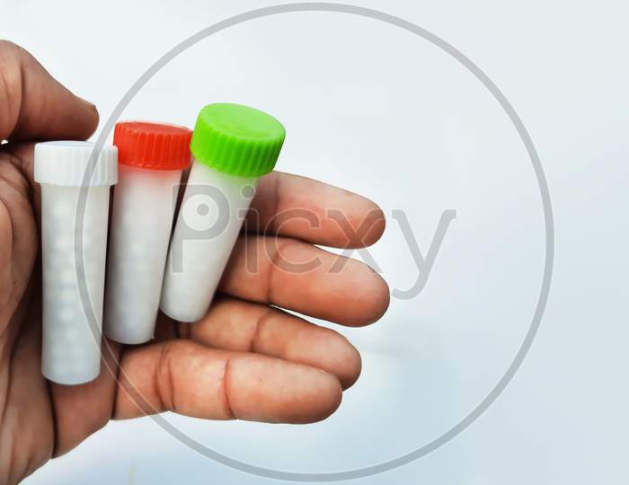 Homeopathic Medicines In Small Bottles Hold In Hands In White Background