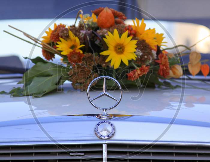 Wedding Flowers Behind Mercedes Benz Car On Hood