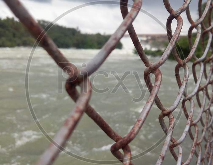 View of cauvery river outflow from KRS dam, viewing from behind cage on the riverbank