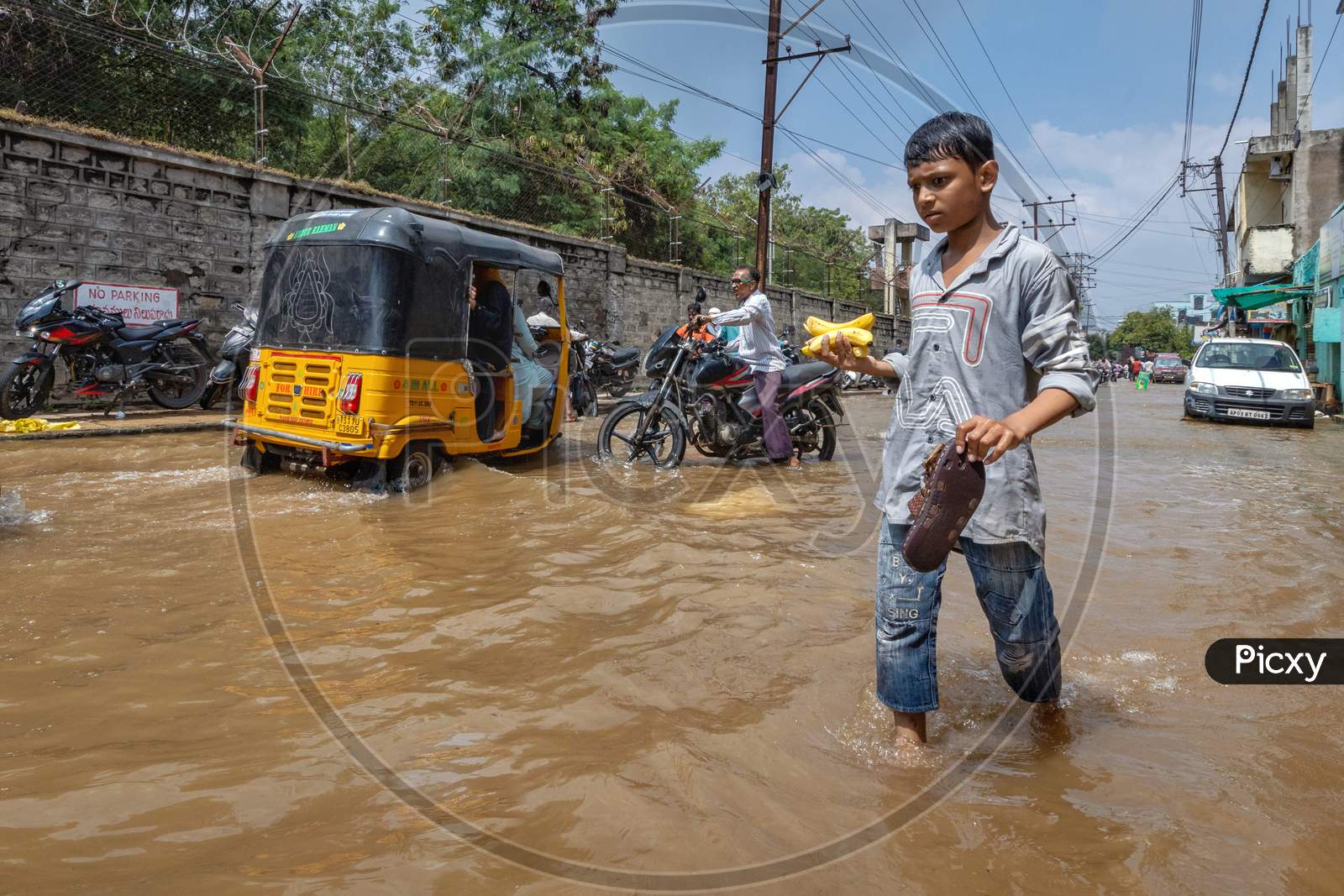 A Boy carrying bananas in the flood water occupied streets in the Hafiz Baba Nagar due to Hyderabad floods