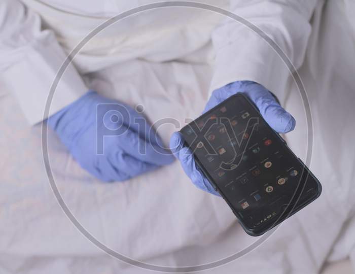 Doctor Using Smartphone App In Hospital Office, Close Up Of Female Person Hands Holding Mobile Phone With Blank Screen As Mock Up Copy Space.