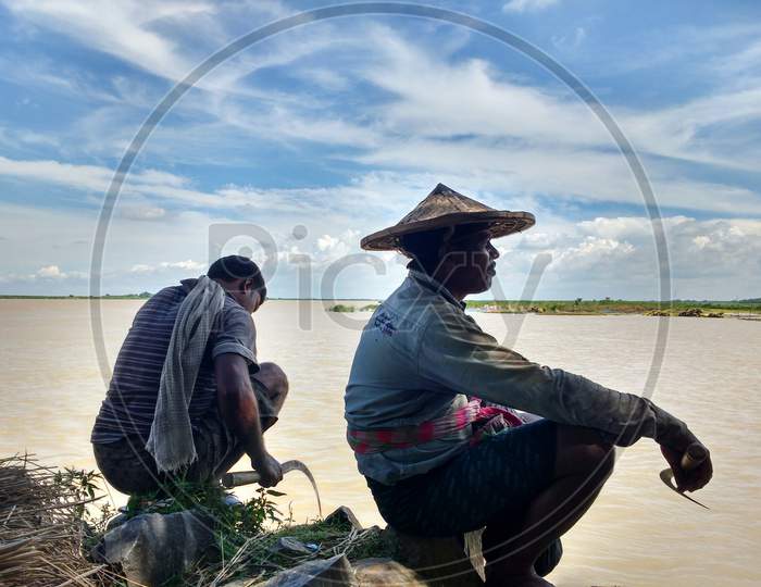 Fisherman On River Bank Stock Photo