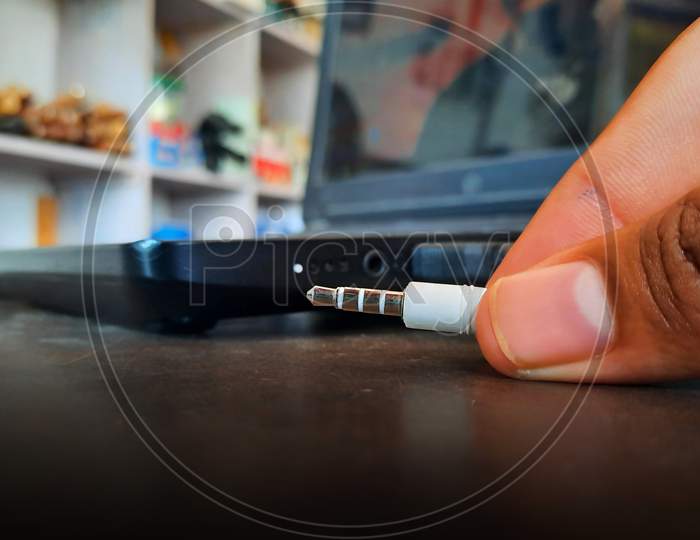 Man Connecting Headphones 3.5 Mm Jack In Laptop