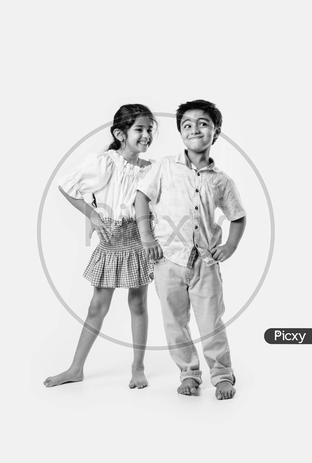 Indian Asian Cute Little Siblings Embracing While Wearing White Cloths Against White Background