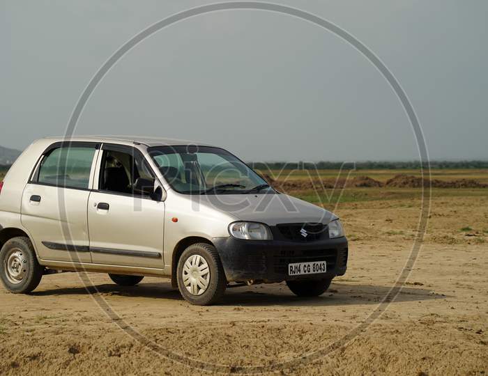Sikar, Rajasthan, India - July 2020: A Maruti alto is standing lonely in empty field on sunny days