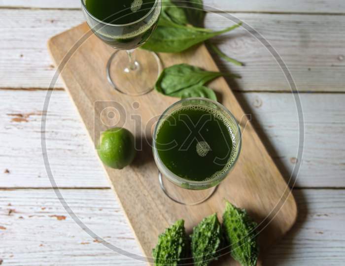 Top view of vegetable juice in a glass on a wooden board