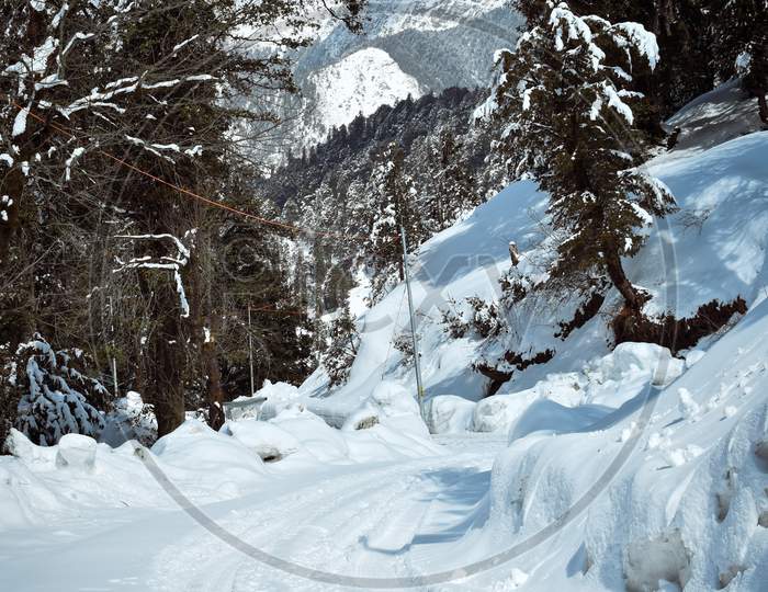 Breath taking view of Snowy road heading towards snowy mountain in manali, Himachal Pradesh.