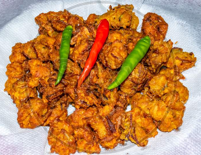Indian spicy chicken pakora serve with green and red chilies