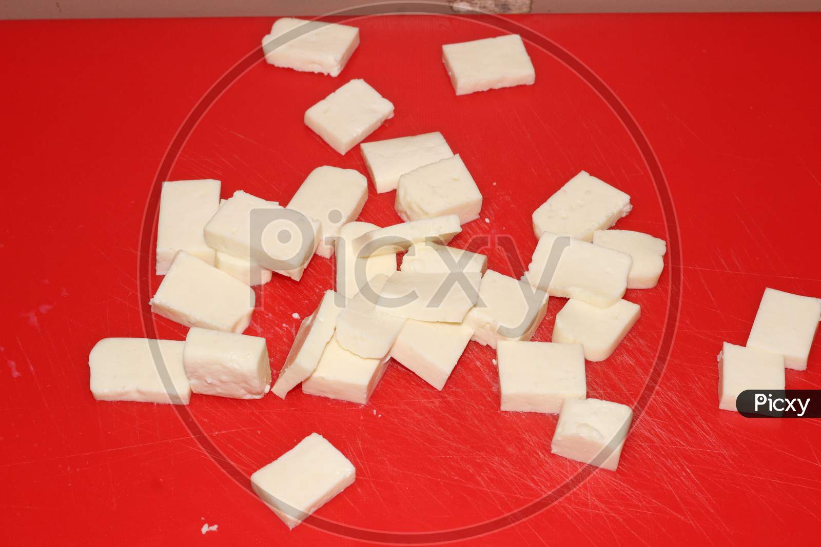 Image of Closeup of paneer cut into pieces on cutting board-JH078418-Picxy