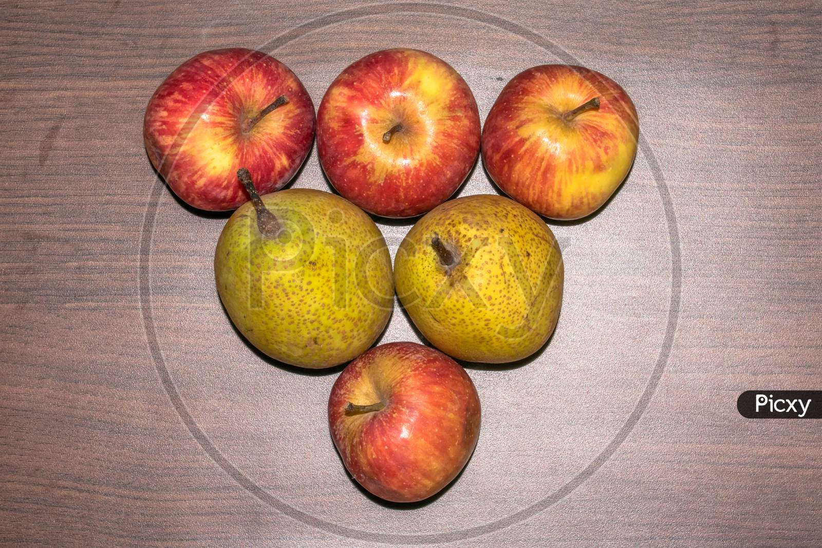 Healthy tasty juicy apples and pears arranged on a brown wooden board