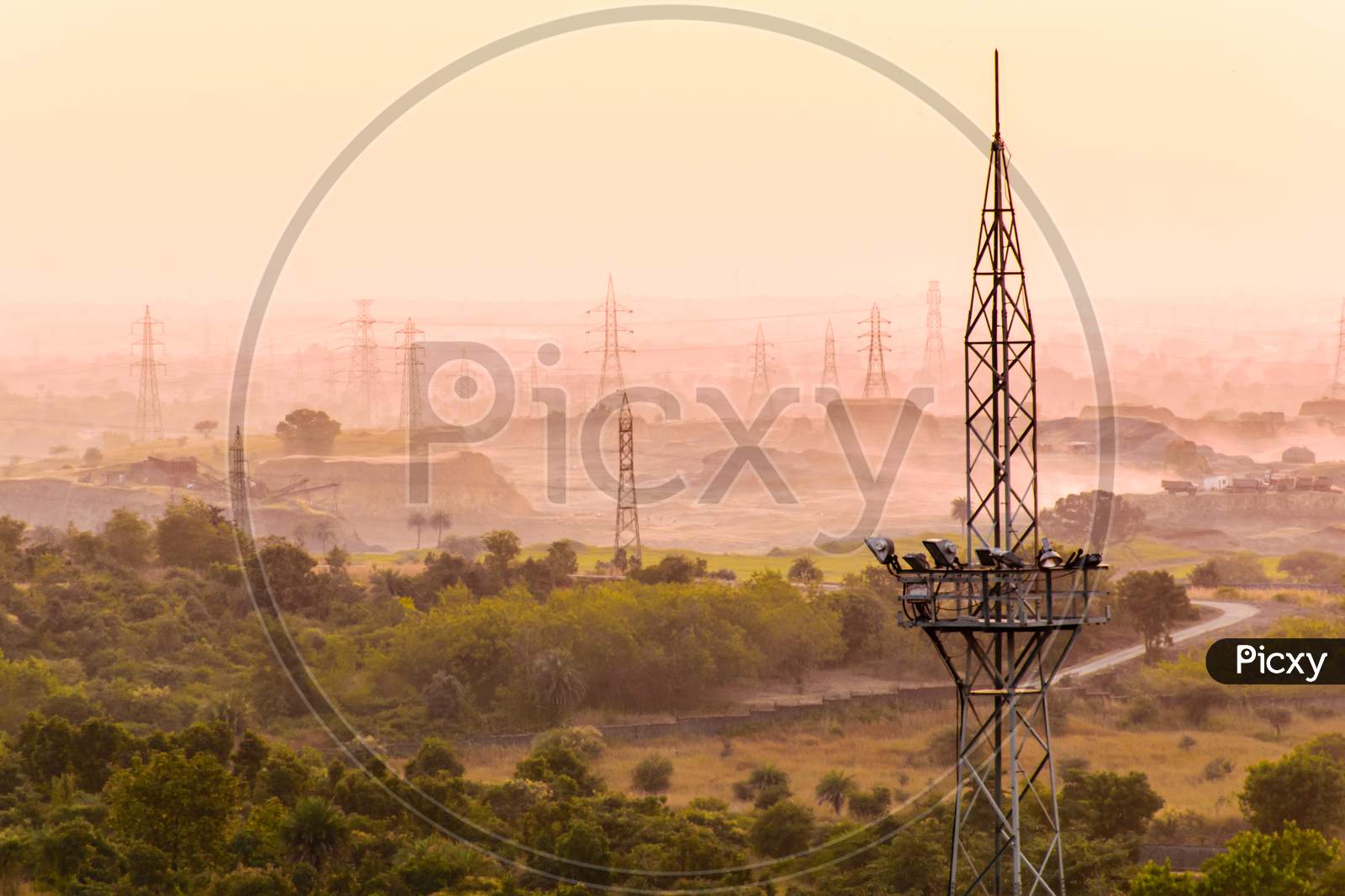 Electrical Power Distribution Towers In Misty Landscape.