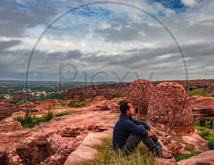 Man Sitting At Mountain Top And Watching The Ruins Of Historical Fort At Morning