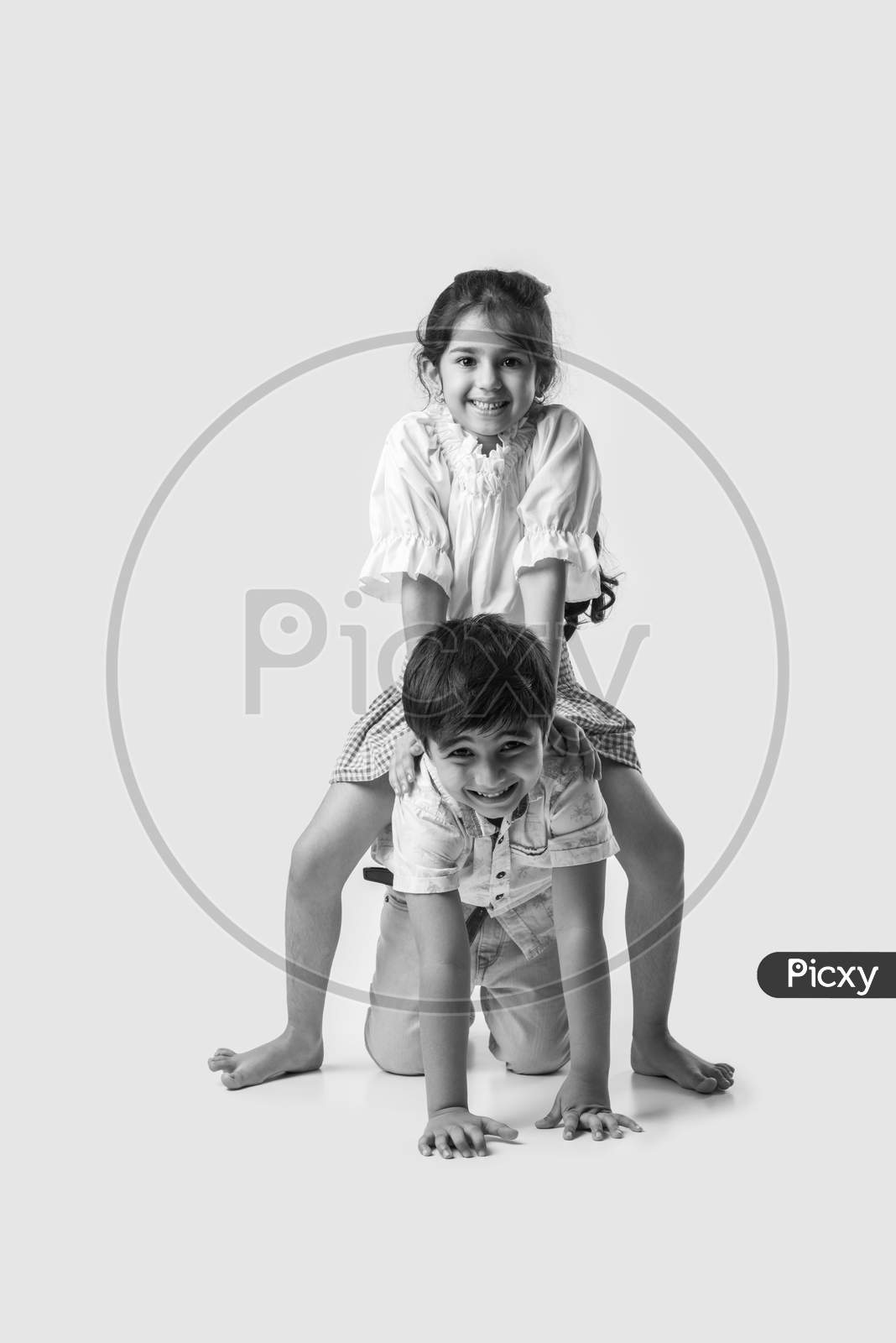 Two Happy Excited Indian Kids Having Fun, Riding On The Back At Home