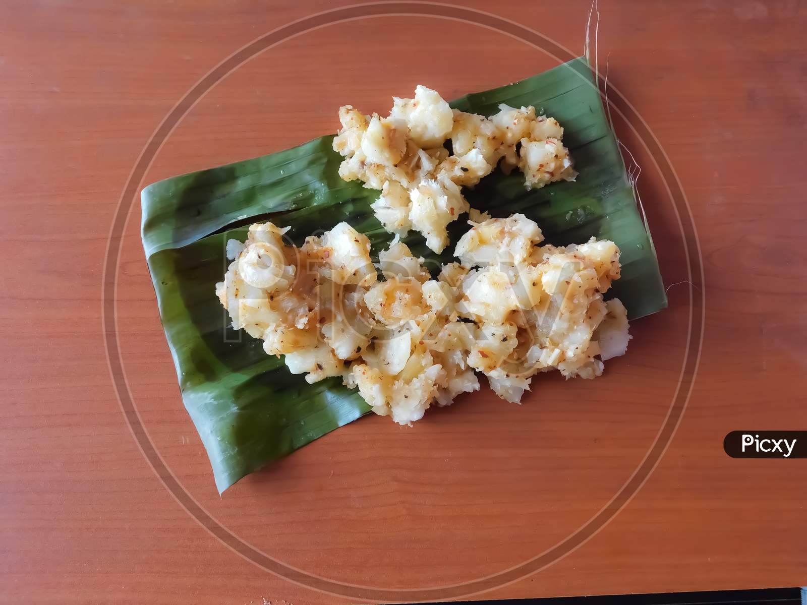 Closeup Of Tapioca Curry In A Banana Leaf Isolated On A Wooden Surface