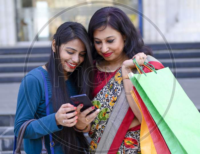 Mother and daughter are taking a selfie outdoor during a shopping day